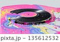 Glossy vinyl record melts into a pool of neon colors on a flat surface 135612532