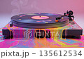 Glossy vinyl record melts into a pool of neon colors on a turntable 135612534