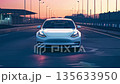 黄昏時の道路上の白いテスラ車 135633950