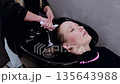 Woman getting her hair done by another woman 135643988