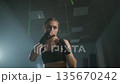 Slow motion, woman fighter trains his punches, beats a punching bag, training day in the boxing gym, strength fit body, the girl strikes fast. 135670242