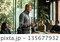 Middle-aged African HR manager leading a diverse team meeting in a modern conference room 135677932
