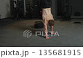 Handstand training in gym by athlete focusing on strength and balance in early morning session 135681915