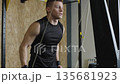 Athlete trains with pull-ups for strength in fitness studio at indoor training session 135681923