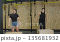 Athletes perform box jumps for strength training at a fitness center in the morning 135681932