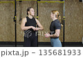 Two athletes share workout tips in gym setting focused on improving training performance and techniques Two athletes share workout tips in gym setting focused on improving training performance and techniques 135681933
