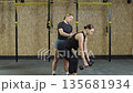 Fitness coach helps athlete with dumbbell technique in training session at gym in October Fitness coach helps athlete with dumbbell technique in training session at gym in October 135681934