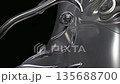 A close-up of a shiny, abstract metallic sculpture with smooth curves and reflective surfaces. The background is dark, enhancing the sculpture's features. 135688700
