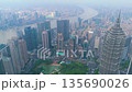 Aerial of dense financial district skyscrapers, an urban park, and the Huangpu River in hazy 135690026