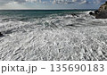 Strong ocean waves hit rocky shore creating white foam under cloudy sky in Bogliasco Italy in slow motion 120fps 135690183