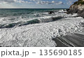Strong ocean waves hit rocky shore creating white foam under cloudy sky in Bogliasco Italy in slow motion 120fps 135690185