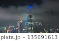 Aerial shot of illuminated modern skyscrapers rising above low fog and clouds during the night in 135691613