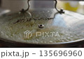 Close-up, steam escaping from under the lid of a pot with corn boiling in it 135696960