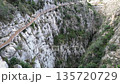A drone flies over a beautiful tourist canyon in Spain, a wooden path along the cliff, 135720729