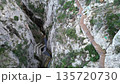 Aerial drone footage flying over a dramatic canyon with a wooden walkway built along the cliff for 135720730
