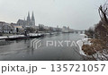 Winter snow over Danube River cathedral and stone bridge in Regensburg Germany slow motion 135721057