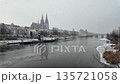 Winter snow over Danube River cathedral and stone bridge in Regensburg Germany slow motion 135721058