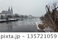 Winter snow over Danube River cathedral and stone bridge in Regensburg Germany slow motion 135721059
