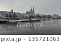 Winter snow falling over Danube River cathedral and stone bridge in Regensburg Germany 135721063