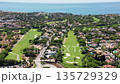 Vale de Lobo, Algarve, aerial view parallel fairways and luxury homes stretching toward coastline, tree lined greens, bunkers and manicured gardens, sunny Mediterranean light, upbeat holiday 135729329
