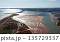 Aerial drone view over Alvor estuary in Algarve, Portugal, showing tidal sandbanks, coastal wetlands, and reflective waters under sunlight. Concept of natural beauty and ecological diversity 135729337
