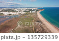 Alvor aerial view drone aerial coastline stretch with golden beach and turquoise sea, dune path and nearby golf greens leading to resort skyline, clear blue water edged by sandy shore, ideal 135729339
