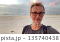 short shair woman in glasses making beach selfie 135740438