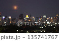 Blurry video high buildings and the moon rises behind the urban landscape during early evening 135741767