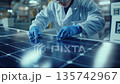 Worker assembling solar panels in a manufacturing facility during daylight hours 135742967