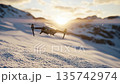 Drone flying over snowy mountains during sunset with beautiful light and winter scenery 135742974
