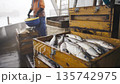 Fishermen gather the ocean catch in wooden crates on a foggy day at sea 135742975