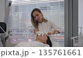 Cosmetologist performing mesotherapy microneedling treatment on middle-aged woman face, applying advanced skincare technology for professional beauty and anti-aging procedures in clinical environment. 135761661