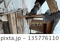 a man splitting a log into kindling with an axe. snow lies outside. close-up. vertical video a man splitting a log into kindling with an axe. snow lies outside. close-up. vertical video 135776110