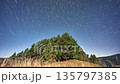 Night sky star trails timelapse over pine trees forest in bright moonlight. 135797385
