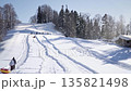 A lot of people are vacationing at the ski resort. The family is tubing in the snow. Fun, active recreation 135821498