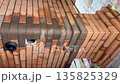 building a heating stove. made of multicolored bricks. shows a chimney with a flue spreader. a convection heating pipe and a stove bench. vertical video. building a heating stove. made of multicolored bricks. shows a chimney with a flue spreader. a convection heating pipe and a stove bench. vertical video. 135825329