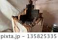 demolition of an old heating stove in an emergency state with signs of wear. cracks in the brickwork and soot stains demolition of an old heating stove in an emergency state with signs of wear. cracks in the brickwork and soot stains 135825335