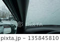 Snowfall coats glass and mirrors, Serene street scene with icy windshield and snowcovered surroundings 135845810