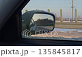 Car window view, Inside vehicle observing expansive open road with snowy shoulders and faroff trees 135845817