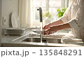 A scene of careful housework as people wash dishes in a quiet morning kitchen 135848291