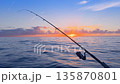 Offshore bottom fishing at sunset from boat with rod over calm sea 135870801