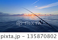 Offshore bottom fishing at sunset from boat with rod over calm sea 135870802