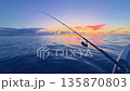 Offshore bottom fishing at sunset from boat with rod over calm sea 135870803