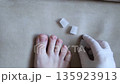 Silicone toe sleeve or cap. Woman puts on protective cover on little toe. Fights corns, prevents blisters and ingrown toenails 135923913