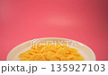 Corn flakes with milk macro, vibrant pink background, slow motion 135927103