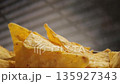 Corn chips close-up, mexican nachos, slow motion footage of crispy yellow tortilla chips 135927343