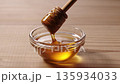 Lifting honey with a honey dipper 135934033