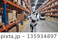A humanoid logistics robot working in a distribution warehouse carefully picks cardboard boxes from shelves and delivers them to a picker. 135934897