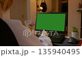 Woman working on laptop in home office with green screen for content creation 135940495