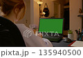 Woman having video call on laptop with green screen 135940500